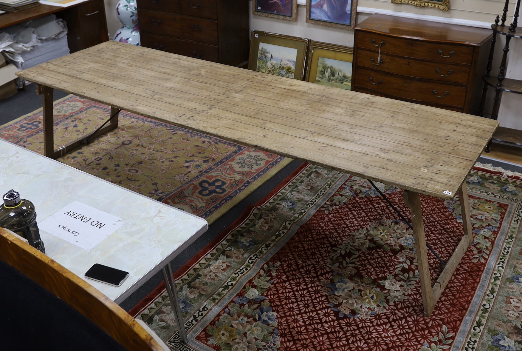 A large French rectangular pine and wrought iron folding trestle table, length 300cm, depth 91cm, height 74cm